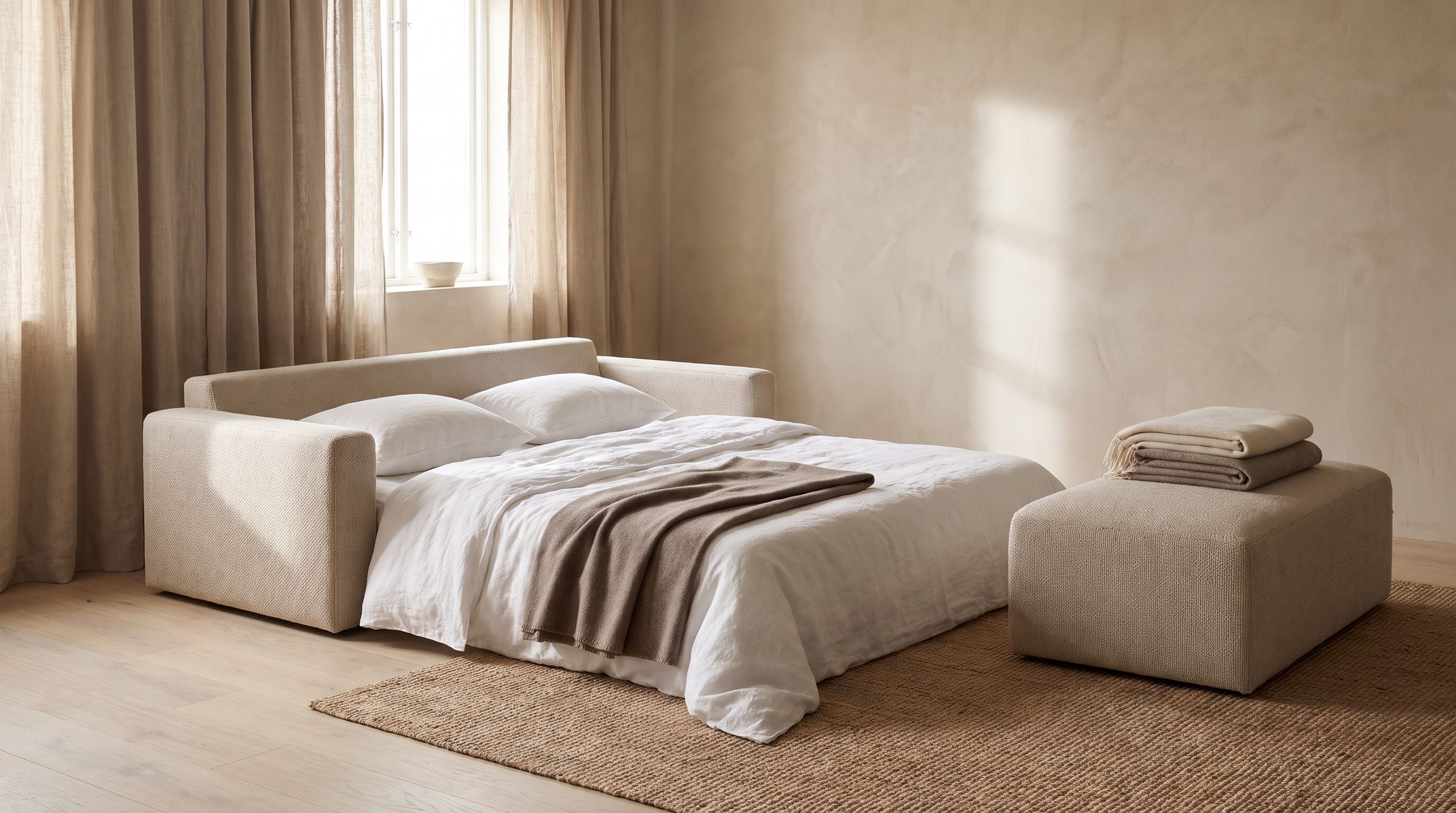A low foam sofa unfolded into a bed with linen sheets